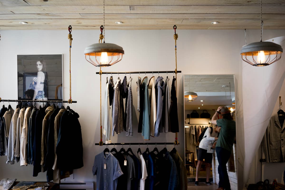 Clothing shop interior with painted walls, rails and pendant lights